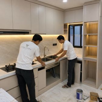 Tim Ruang Warna Interior Jakarta Timur sedang memasang wastafel stainless pada kitchen set modern custom dengan tampilan clean dan premium.